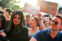 Lachendes Publikum. Frau hält Schild: Quanto Costa die Liebe zu Dir?
