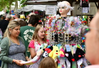 Frau und Mädchen an einem Marktstand mit Sonnenbrillen