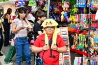 Junge mit Pikachu-Mütze vor einem Marktstand