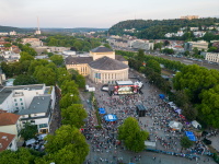 Luftaufnahme des Altstadtfests in Saarbrücken mit Blick auf das Staatstheater. Vor dem Gebäude ist die Hauptbühne aufgebaut, davor versammelt sich eine große Menschenmenge. Rundherum Stände, Zelte und lebhaftes Festtreiben.