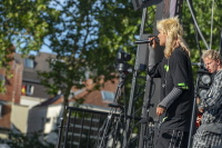 Blonde Sängerin mit wilder Mähne performt energiegeladen neben Gitarrist auf der Bühne.
